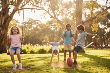 Children of different ages from 6 to 13 playing together outdoors, representing the K9 AI Kids Watch age range of 5 to 14 years